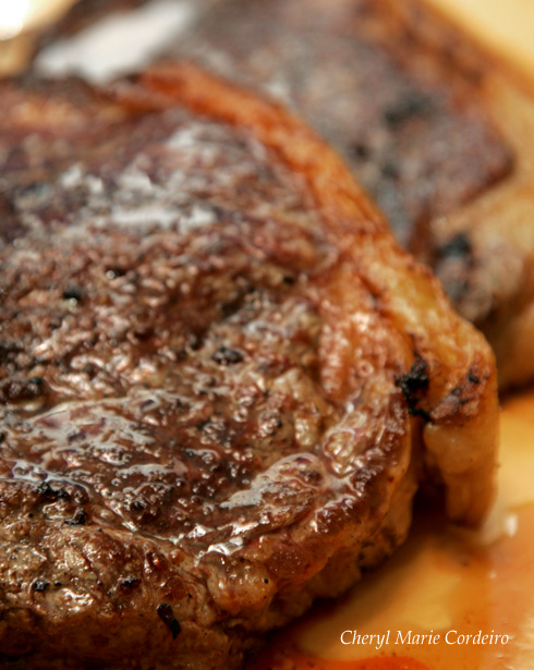 T-bone steak grilled over firewood stove, bistecca alla fiorentino style.