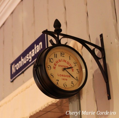 An antique clock hangs on the wall inside this chocolate and caramel shop in Kronhuset.