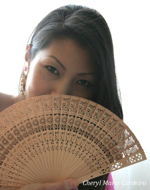 Cheryl Marie Cordeiro-Nilsson, behind a Chinese wood-carved fan.