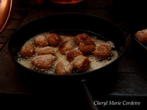 Frying the Swedish meatballs in a cast iron pan till crisp and golden brown