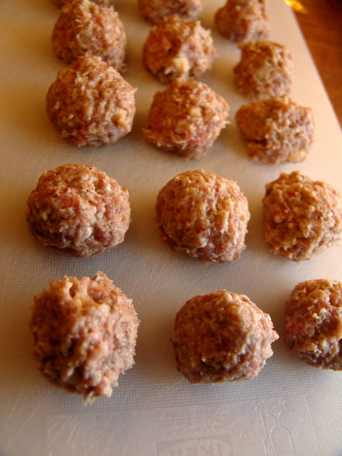 Unfried Swedish meatballs lined up on the chopper board