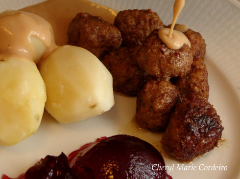 Swedish meatballs served with potatoes, brown sauce and red currant jam or lingonberry jam