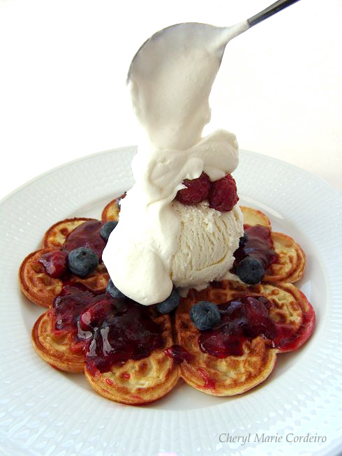 Homemade heart shaped waffles with raspberries, blueberries and cream