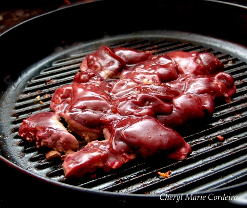Chicken liver in a cast iron grill pan. At Cheryl Marie Cordeiro