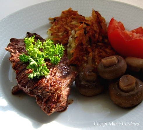 Beef steak served with rösti, mushrooms and tomato. At Cheryl Marie Cordeiro