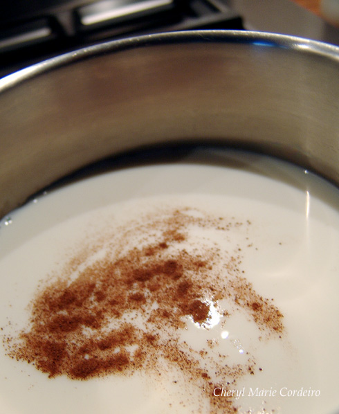 Milk in a pot, on a stove with cinnamon, ready for gyllenmust making