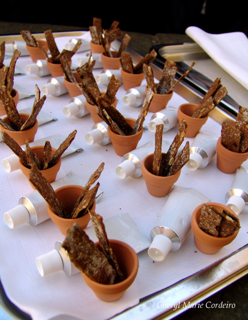 Sour dough breadsticks served in tiny ceramic pots, with a tube of pate.