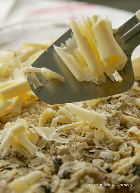 Using a cheese cutter to shave butter is effective for this apple and banana crumble project.